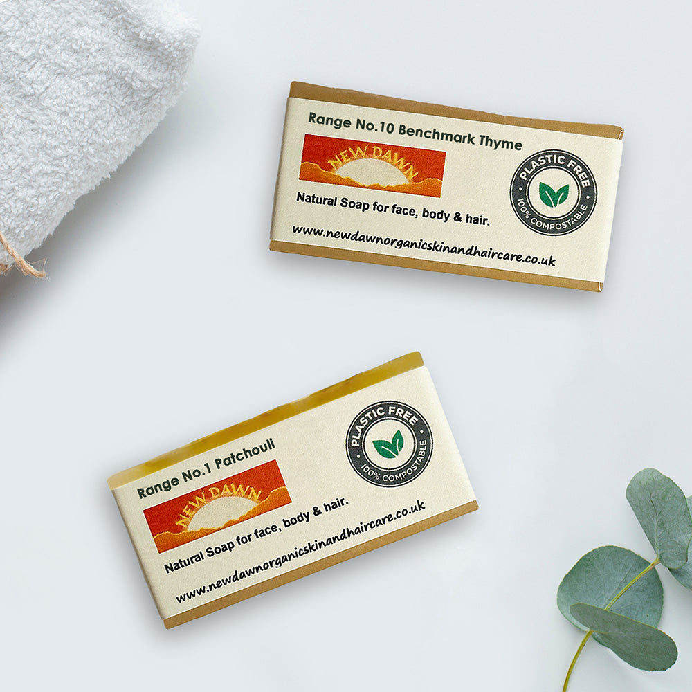 Two natural soaps on a table next to a towel.